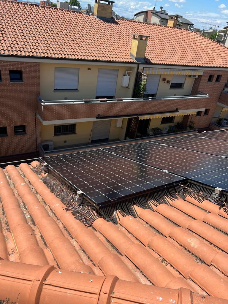 Solar panels installed on a terracotta tile roof of a brick residential building with multiple unit apartments visible.